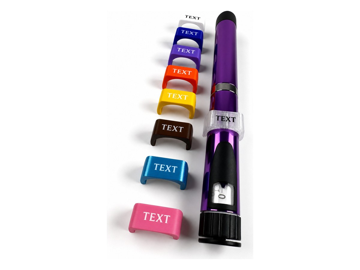 Eight V2 pen tags in white, blue, purple, orange, yellow, brown, light blue and pink, each printed with a sample label, beside an auto-injector pen wearing a clear tag